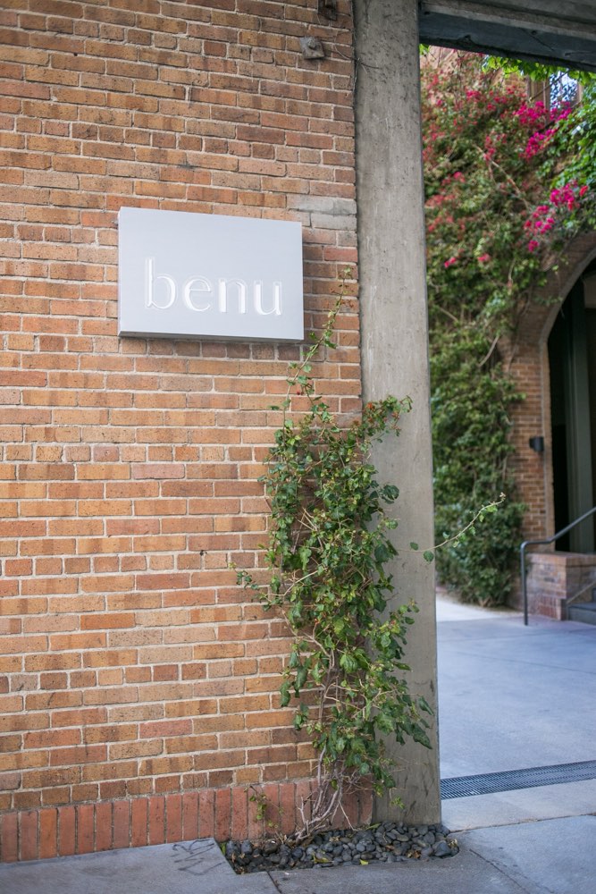 The Benu sign on a brick wall beside the courtyard entrance, San Francisco