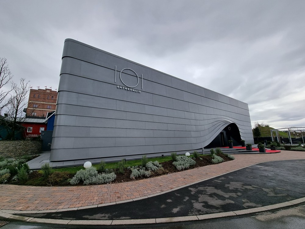 The curved grey building of Eatrenalin with its logo, Rust