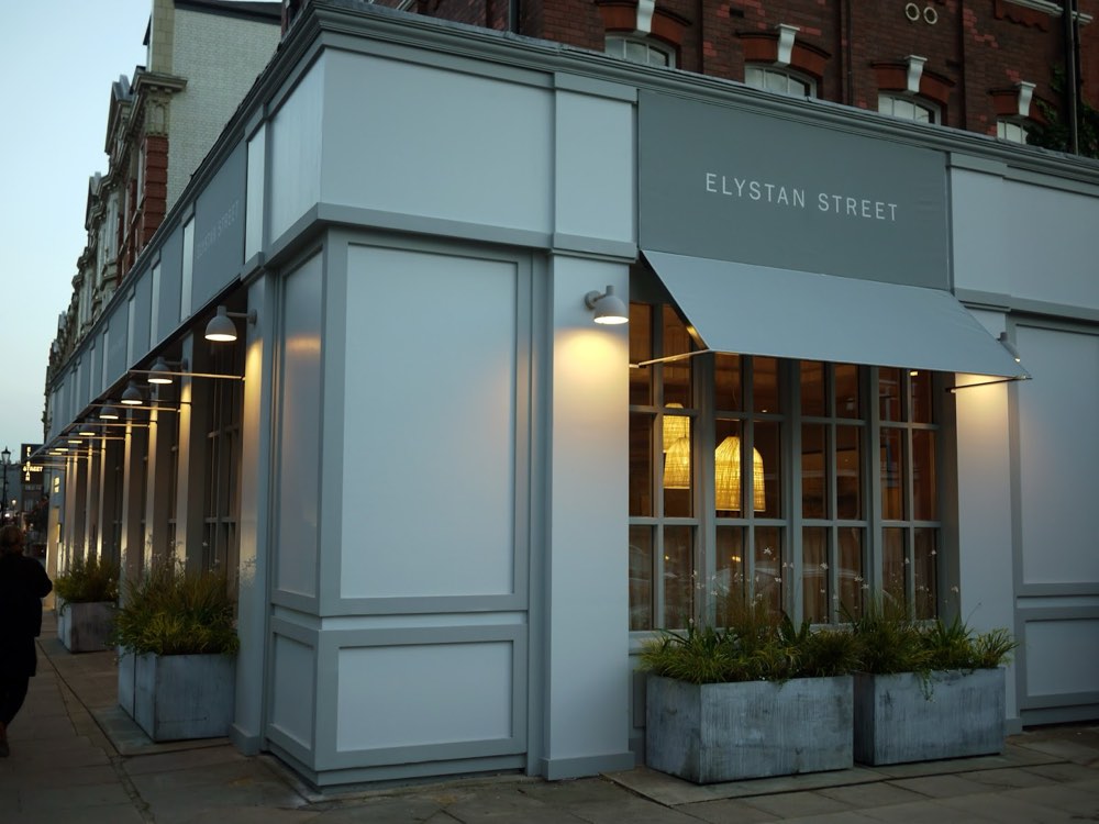 The corner front of Elystan Street restaurant in Chelsea, London, with its name above the windows