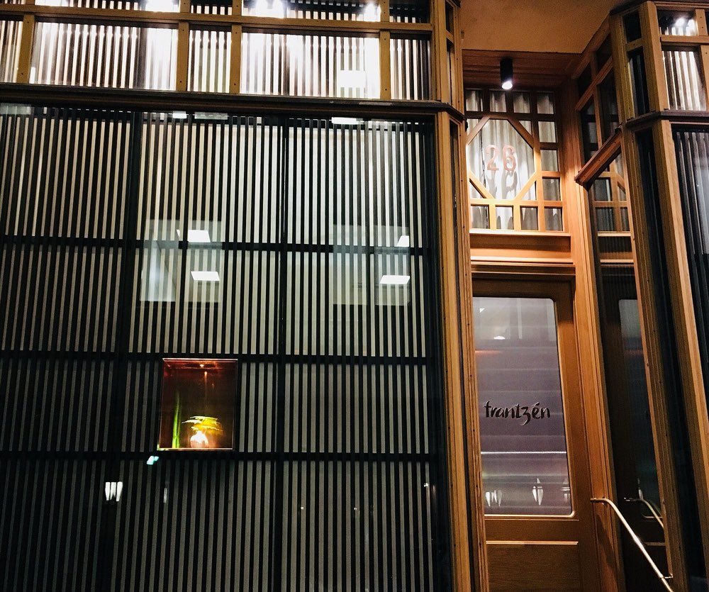 The lit entrance of Frantzén with its name on the door, Stockholm