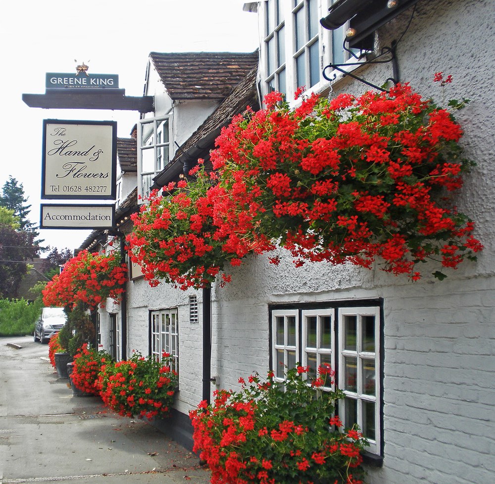 The Hand & Flowers sign and flower baskets on its whitewashed front, Marlow