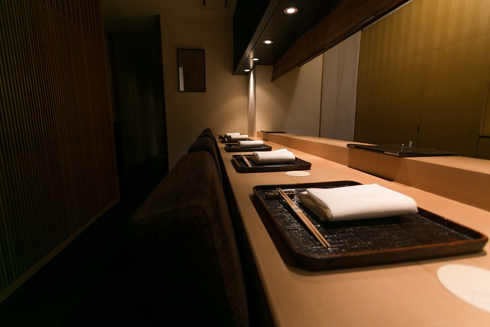 The wooden counter of Kagurazaka Ishikawa, Tokyo, laid for dinner