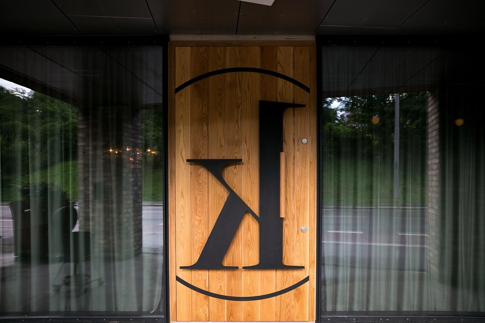 The entrance door of Kontrast in Oslo, marked with a large K