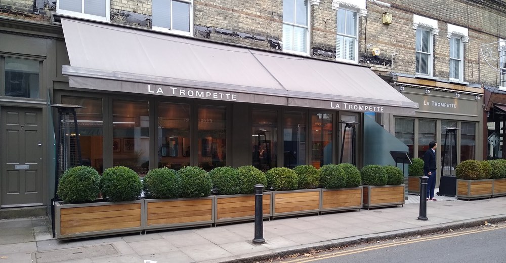 The front of La Trompette with its name on the awning, Chiswick, London
