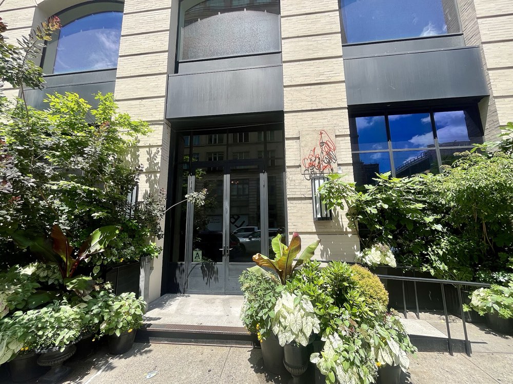 The entrance of Le Coucou at 138 Lafayette Street, Manhattan, framed by plants