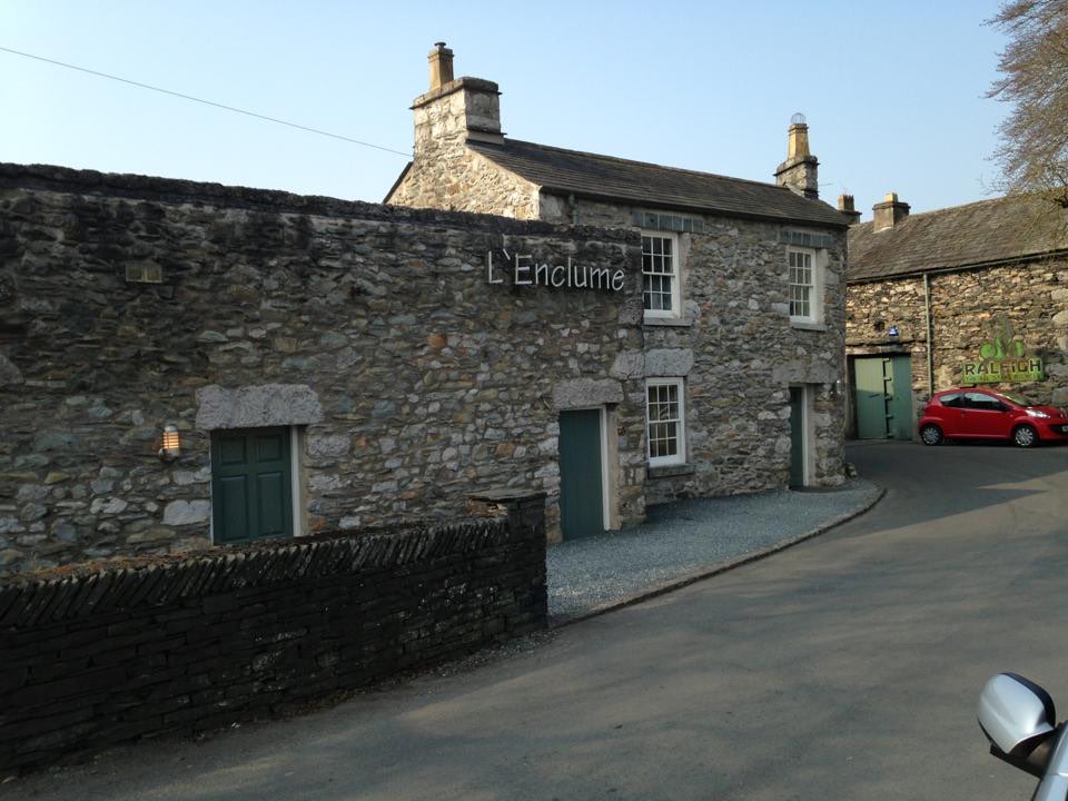 The stone building of L'Enclume in Cartmel, Cumbria, with its name on the wall