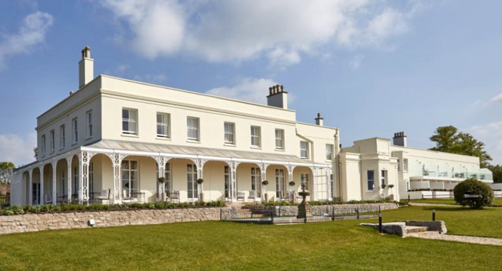 The white Georgian front of Lympstone Manor in Devon, across its lawn