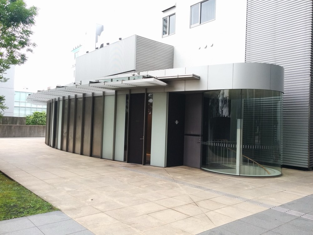 The curved glass entrance of the building housing NARISAWA in Minami-Aoyama, Tokyo