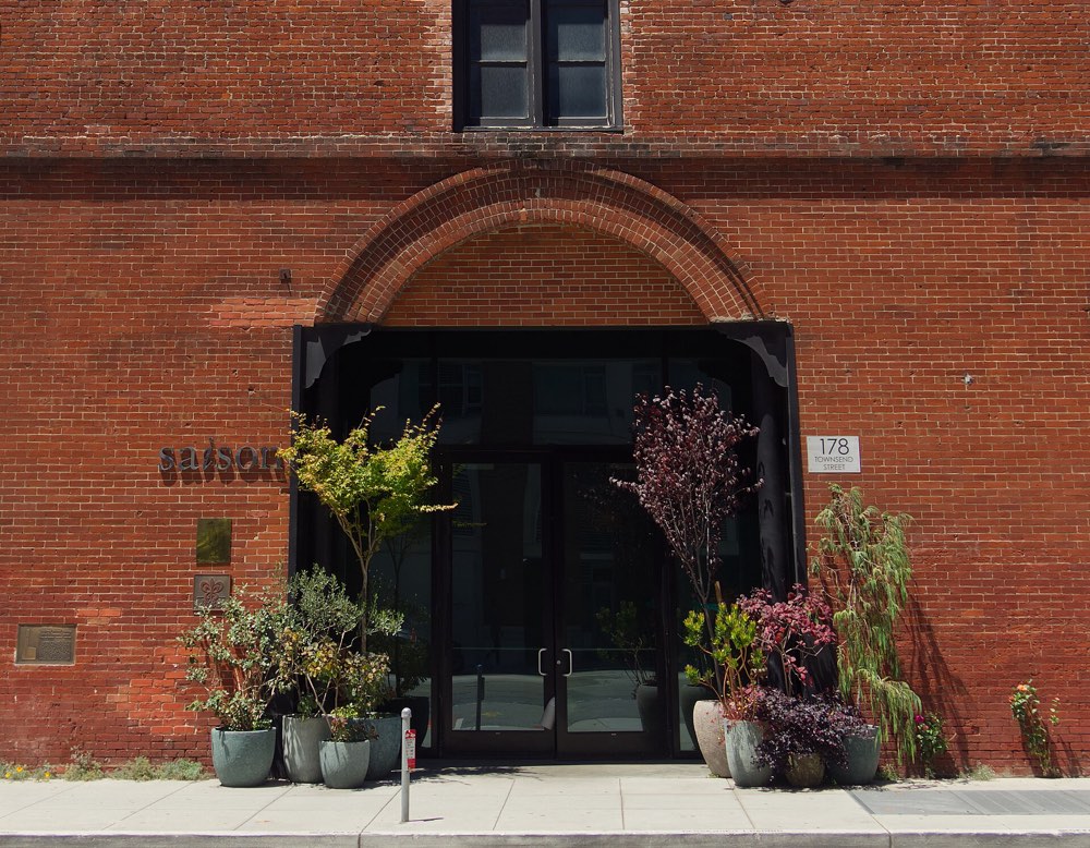 The arched brick entrance of Saison with its name on the wall, San Francisco