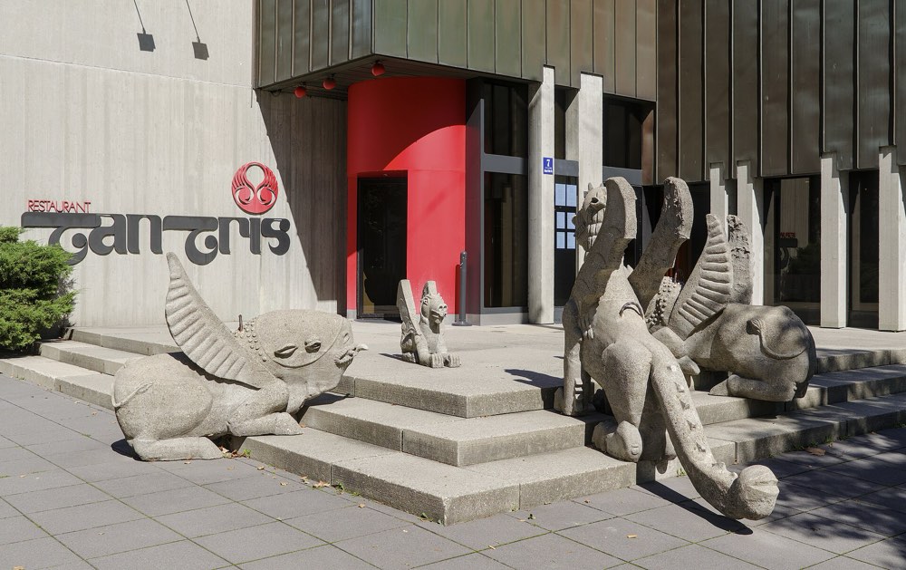 The red entrance of Tantris with its name and stone creatures, Munich