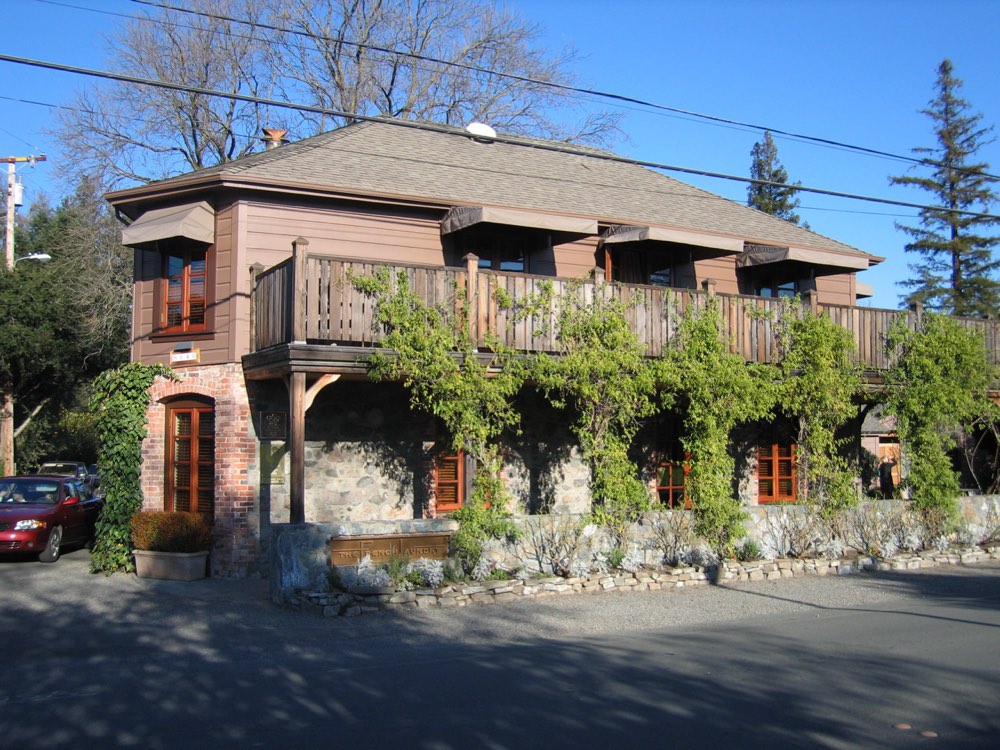 The stone and wood building of The French Laundry in Yountville, California, covered in vines