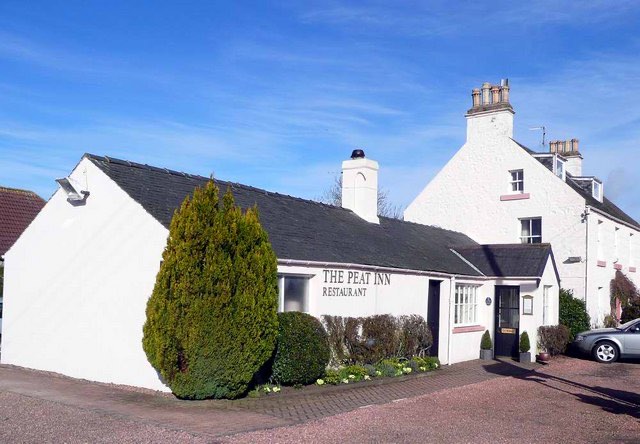 The white Peat Inn restaurant building in Fife, with its name on the wall