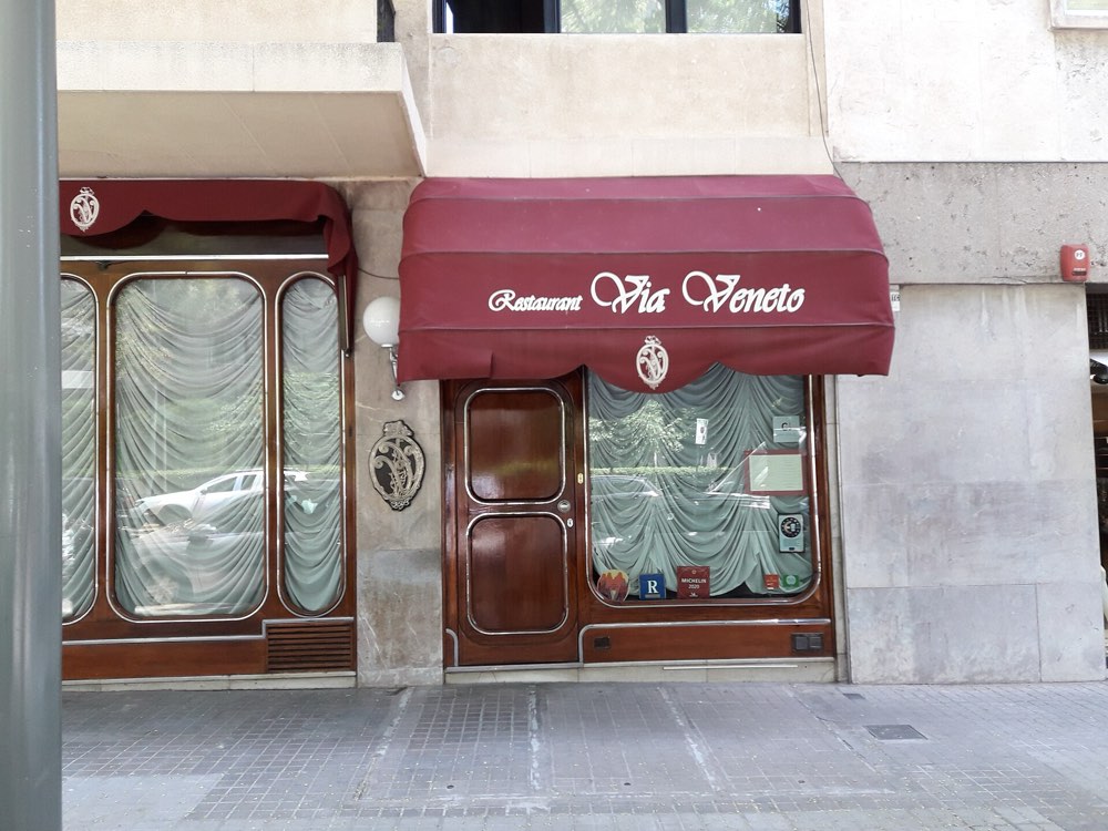 The red awning and wooden door of Restaurant Via Veneto on Carrer de Ganduxer, Barcelona